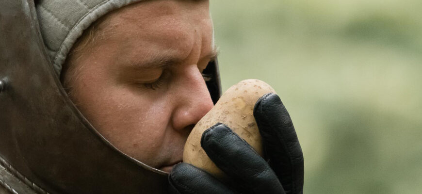 En man luktar på en potatis